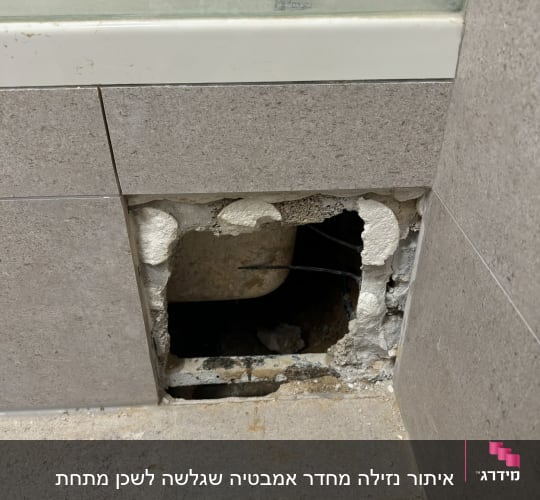 חור בקיר עם צינור חשוף ליד אמבטיה